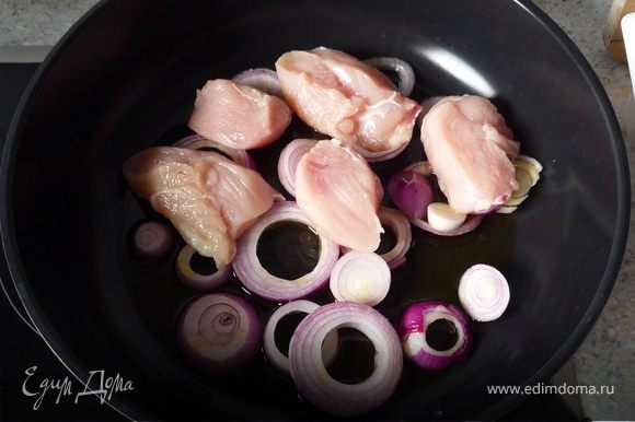 Лук режем кольцами. Куриную грудку на небольшие кусочки. Петрушку мелко рубим. Ставим сковороду на маленький огонь. Выливаем оливковое масло, выкладываем лук и куриное филе.