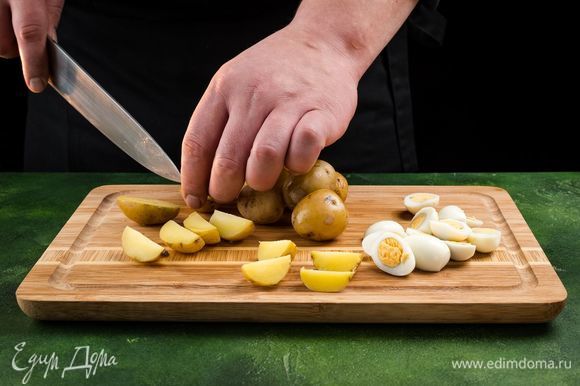 Тщательно вымойте и отварите картофель. Остудите и нарежьте пополам. Отварите перепелиные яйца. Остудите в холодной воде и очистите. Разрежьте пополам.