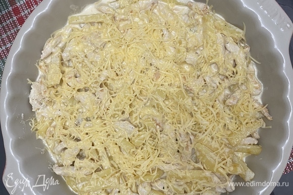 Духовку разогреть до 180–190°C. Переложить со сковороды филе с картофелем в форму для запекания. Посыпать тертым сыром. Запекать 20 минут до румяной корочки.